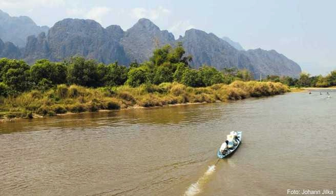 Bootspartie auf dem Xong River bei Vang Vieng. Der Ort ist von schroffen Karstbergen umgeben