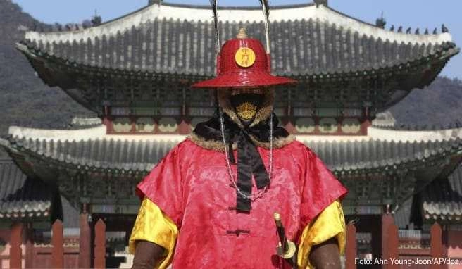 Ein Wachmann der Kaiserlichen Wache in Südkorea trägt einen Atemschutz - angesichts des Coronavirus sollten Reisende in Asien derzeit besonders vorsichtig sein Ein Wachmann der Kaiserlichen Wache in Südkorea trägt einen Atemschutz - angesichts des Coronavirus sollten Reisende in Asien derzeit besonders vorsichtig sein