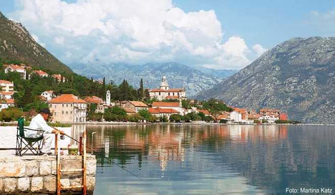 Der hübsche kleine Ort Prc¡anj in der Bucht von Kotor, auf dem Hügel die dominierende Kirche Der hübsche kleine Ort Prc¡anj in der Bucht von Kotor, auf dem Hügel die dominierende Kirche