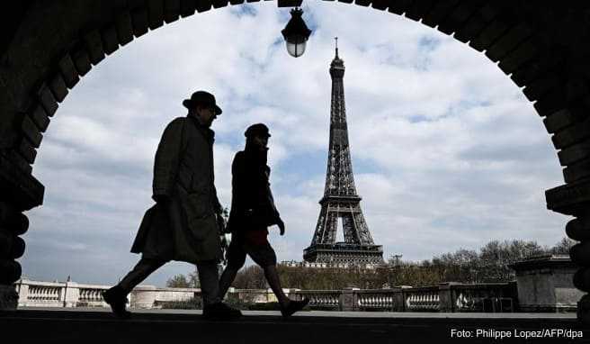 Passanten gehen auf der Brücke «Pont de Bir-Hakeim», mit Blick auf den Eiffelturm