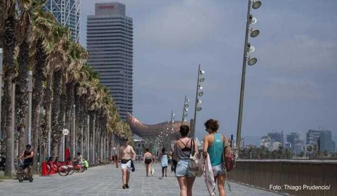 Spaziergänger auf der Strandpromenade in Barcelona