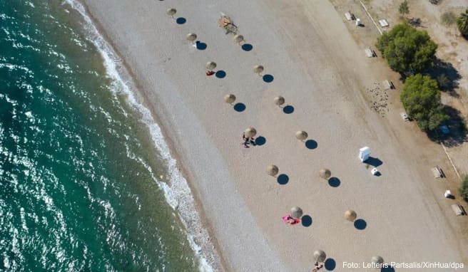An einem Strand südlich von Athen stehen Sonnenschirme für Strandbesucher bereit